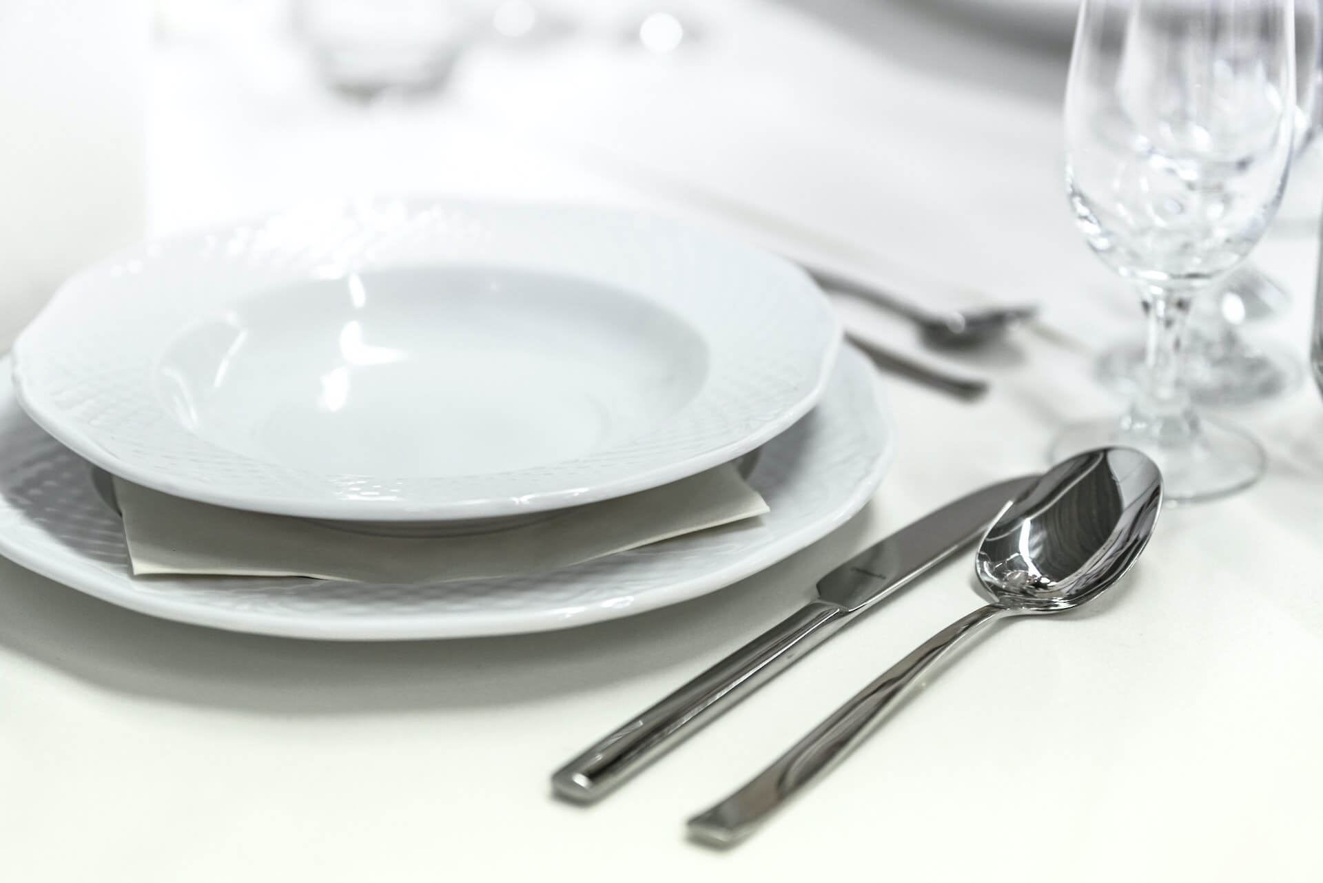 Plates, dishes, cutlery, and glasses in a dinner setting